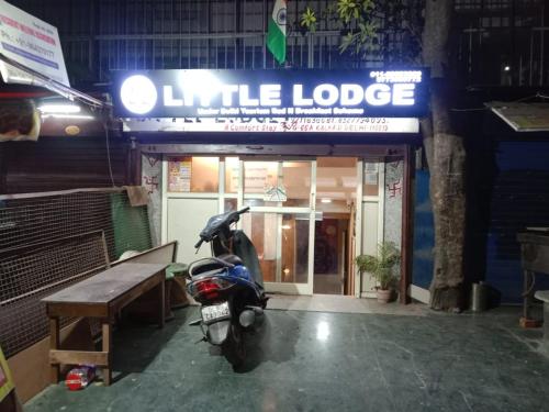 新德里Hotel lodge kalkaji的停在大楼前的摩托车,有标志