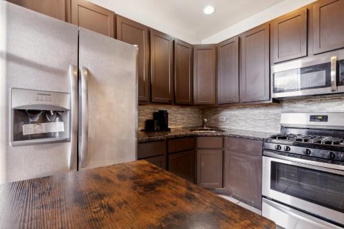芝加哥Comfortable Condo in the Heart of Bronzeville condo的厨房配有木制橱柜和不锈钢冰箱。
