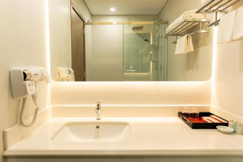 河内首都花园酒店的白色的浴室设有水槽和镜子