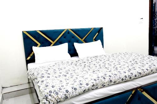 Rāni PokhriJolly Hill Stay的一张带蓝色床头板的床和两个枕头