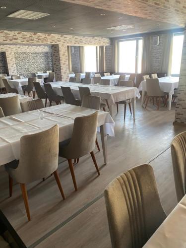 马瑟尔贝格Werrapark Resort Hotel Am Sommerberg的一间设有白色桌椅的用餐室