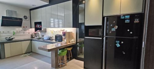 怡保perdana homestay的厨房配有黑色冰箱和台面