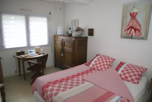 卡尔克富Gîte La Terrasse Du Verger的一间卧室配有一张床、一张桌子和一张带梳妆台的桌子。