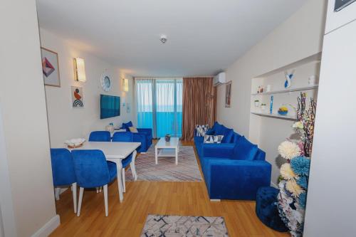 巴统0rbi City Luxury Suites的客厅配有蓝色的椅子和桌子