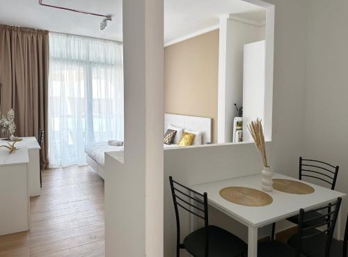 圣朱利安斯Miami Apartments的白色的客房配有桌椅和一间卧室