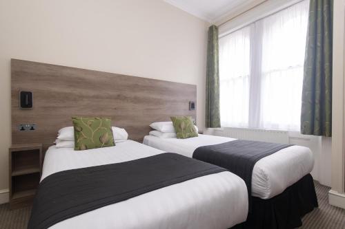 伦敦肯辛顿花园酒店的酒店客房设有两张床和窗户。
