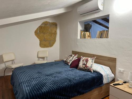 FicarazziM'AMA apartment的一间卧室配有一张带蓝色被子和镜子的床