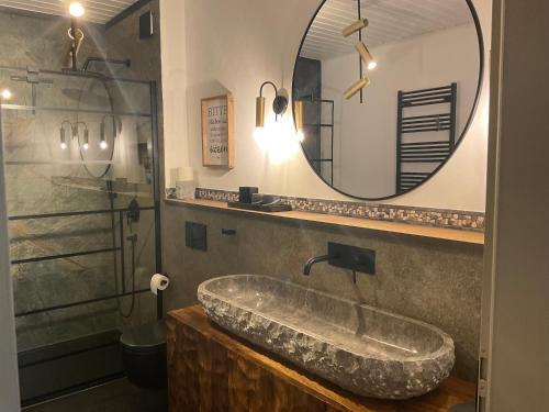 格拉登巴赫zu Jeddelohs Bungalows & Apartments -Adult friendly的一间带大型石质水槽和镜子的浴室