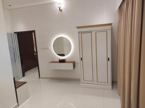 索哈尔Mabahj Garnatha Hotel Apartments的一间设有门、镜子和走廊的房间