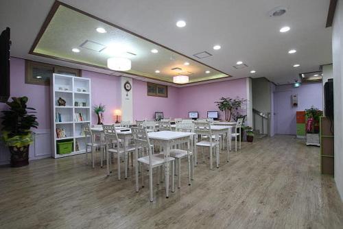 庆州庆州友谊旅馆的一间设有桌椅和紫色墙壁的用餐室