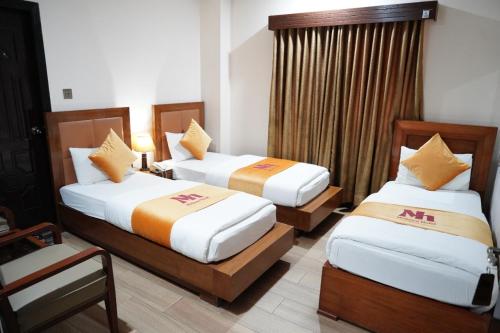 伊斯兰堡Midtwon Hotel Islamabad的一间酒店客房,房间内设有两张床