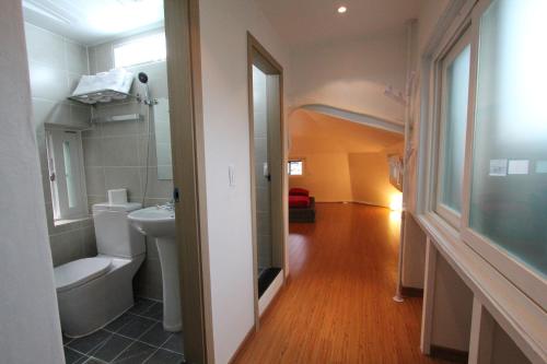 首尔贝麦宾馆的一间带卫生间、水槽和镜子的浴室