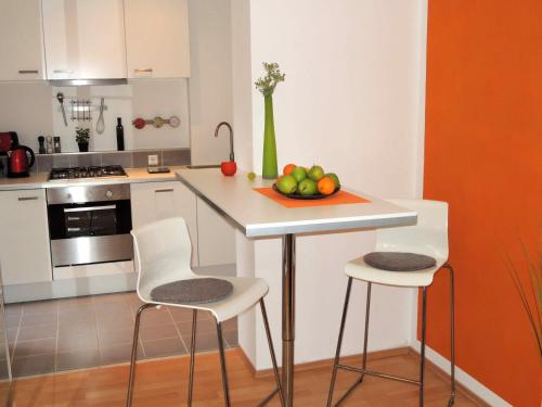 默德林佛伦维拉公寓的厨房配有一张桌子,上面放着一碗水果