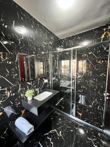 斯库台North Star Hostel的黑色大理石浴室设有水槽和淋浴