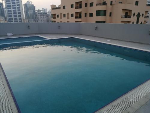 朱菲尔Infinity Juffair Suites的一座建筑物屋顶上的空游泳池