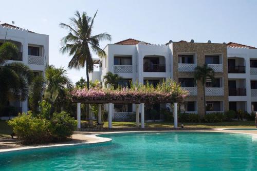 基利菲TAUSI HOMES Sultan Palace Beach Resort的一座带游泳池的度假村,位于一座建筑前