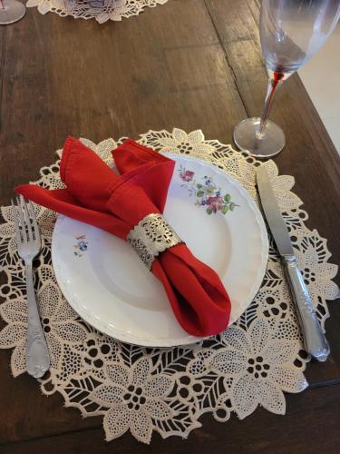 布鲁马迪纽Na trilha da ostra的一张桌子上带红色餐巾的白色盘子