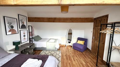 利兹Leeds Cosy House的一间卧室配有两张床和一张紫色椅子