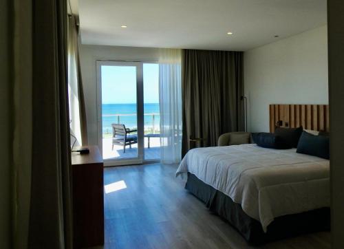 马德普拉塔Ili Ili Hotel Boutique的一间卧室配有一张床,享有海景