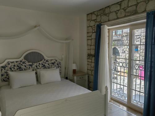 阿拉恰特Mavi Konak Alaçatı的卧室配有白色的床和窗户。