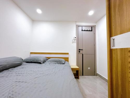 胡志明市Alley Homestay Sai Gon的一间卧室设有一张大床和一扇门