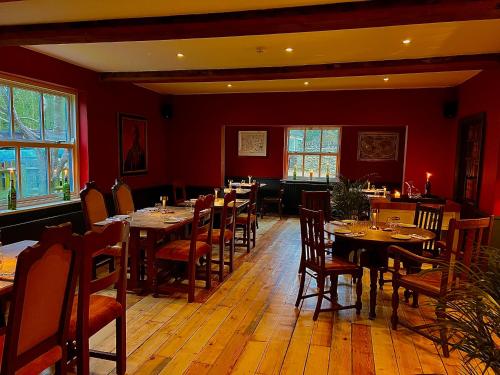 莱奇莱德Five Alls的一间带桌椅和红色墙壁的餐厅