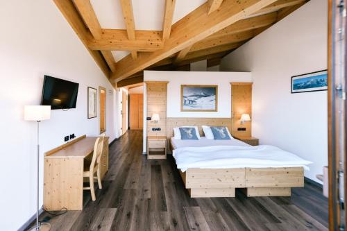 法申凯米特小木屋酒店的一间卧室配有一张床、一张书桌和一台电视。