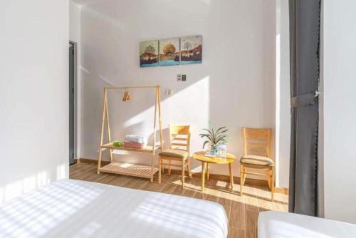 大叻TTG Hostel DaLat的一间卧室配有一张床、两把椅子和一张桌子