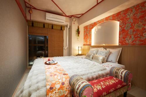 东京Papillon Paradis Higashi-Shinjuku的一间卧室设有一张红色墙壁的大床