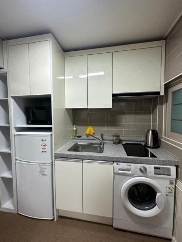 釜山DASOM的厨房配有水槽和洗衣机