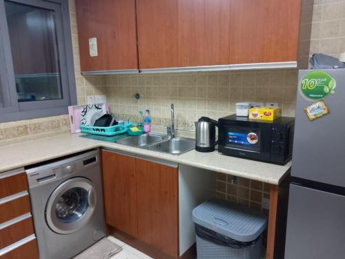 阿布扎比Top House Hostel的厨房配有水槽和洗衣机