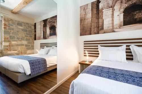 斯普利特阿祖尔宫豪华客房旅馆的一间卧室设有两张床和砖墙