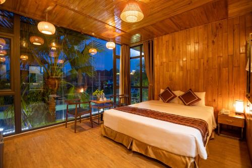宁平Tam Coc Serenity Hotel & Bungalow的一间卧室设有一张床和一个大窗户