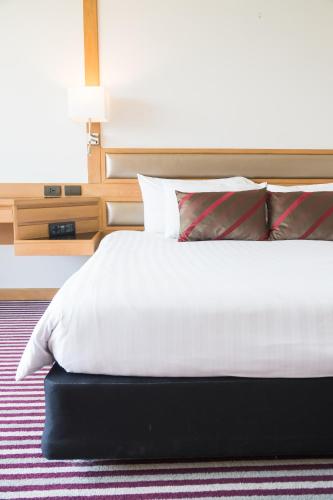 KianyagaPremascape的卧室配有白色床和红色及白色枕头