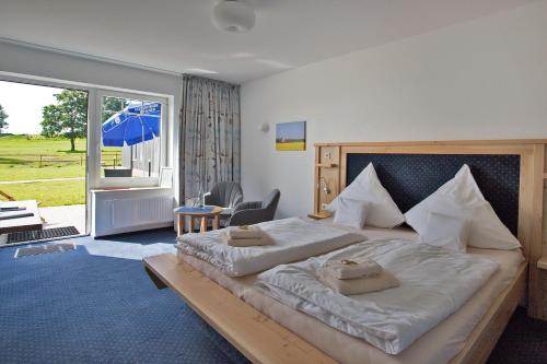 Hamdorf拉福林兹旅馆的一间卧室设有一张大床和一个大窗户