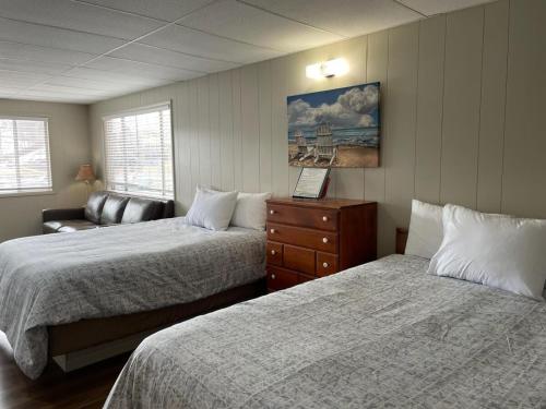 欧塞奇比奇日落海滩度假酒店的酒店客房,设有两张床和一张沙发