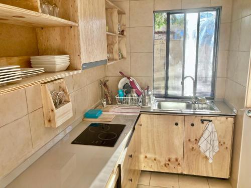 圣地亚哥Urban Lodge Providencia的厨房配有木制橱柜、水槽和窗户。
