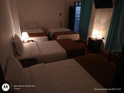 马丘比丘Ortega's House Machupicchu的酒店客房设有两张床和两盏灯。