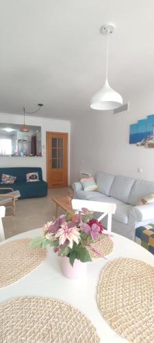 马尼尔瓦Aldea beach 3的客厅配有沙发和鲜花桌