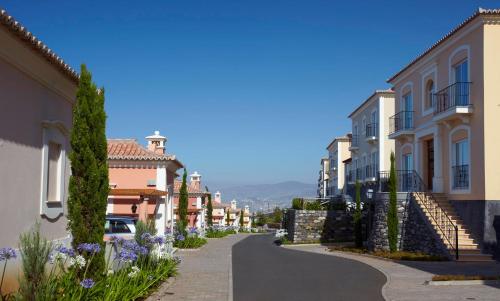 丰沙尔Palheiro Village - Golf, Gardens & Spa的小镇上一条有房子和鲜花的街道