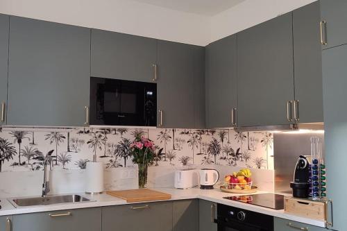 克莱蒙费朗Maison cosy terrasse ensoleillé的厨房配有灰色橱柜和花瓶