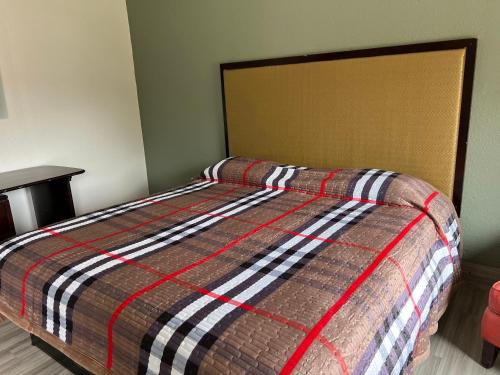 昆西Comfort stay inn的卧室内的一张带条纹棉被的床