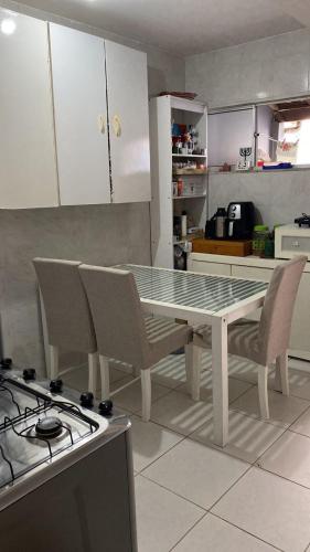 萨尔瓦多Quarto em stella maris的厨房配有桌椅和炉灶。