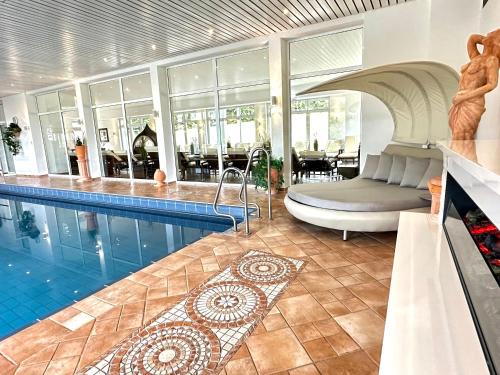 Grasellenbach赛弗里德布鲁门环形酒店的一座房子里一个带床和沙发的游泳池