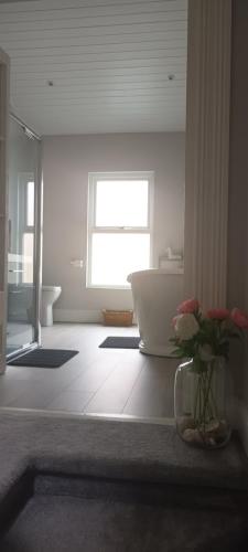 布瑞Eglinton Road - Super King - Private Bathroom的带浴缸和花瓶的浴室