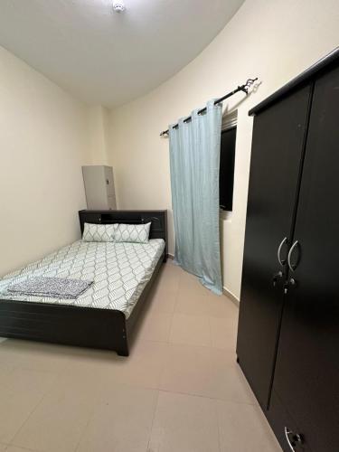 迪拜Palm Inn Hostel的一间卧室配有一张床和一个黑色橱柜