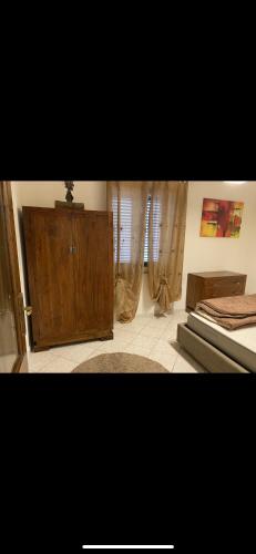 卡斯特尔萨多Trilocale in centro的一间卧室配有一张床和一个木制橱柜