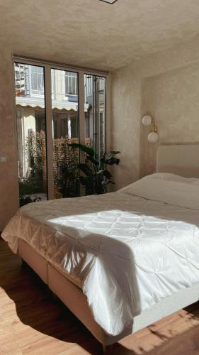 亚琛Atrium Apartments Aachen的卧室设有一张大床,卧室设有大窗户