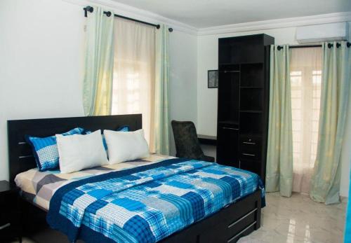 Abeokuta3Tee Serviced Apartment Abeokuta的一间卧室配有一张带蓝白色毯子的床