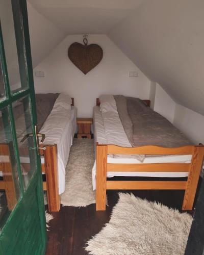 Han PijesakBrvnara Gromki - Mountain house的卧室配有两张床,墙上有心